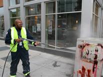 photo of DPW employee removing graffiti from a public surface
