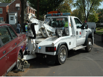 Tow truck with a car on its wench